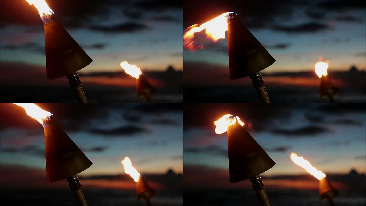 夏威夷考艾岛日落热带海滩上的蒂基火炬火焰
