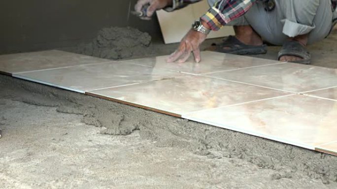 4k，建筑工人用油灰刀铺瓷砖地板