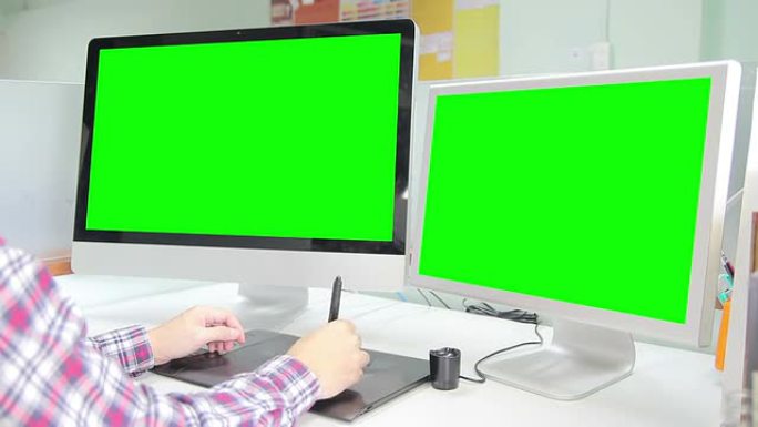 高清：设计师使用2个显示器的绿色屏幕