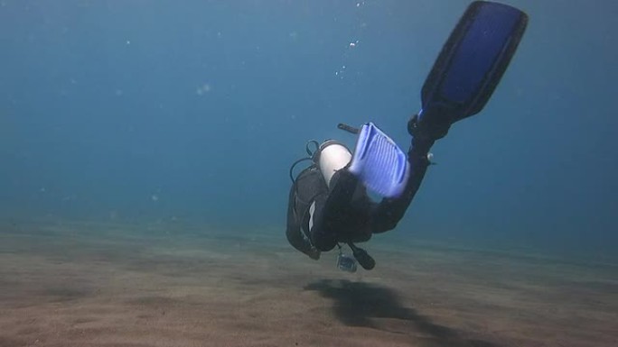 潜水员在海底的火山沙上游泳