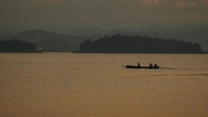 剪影：渔民们正乘坐长船在twlight大坝回家