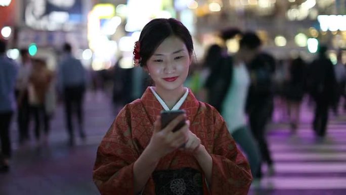 穿着和服的日本女孩在涩谷十字路口发短信