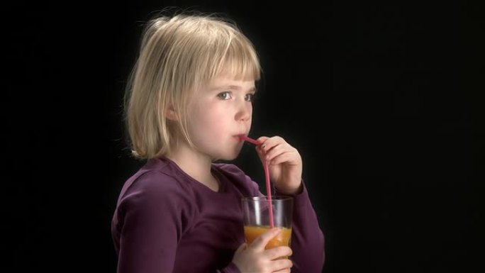 小金发女孩正在享受橙汁