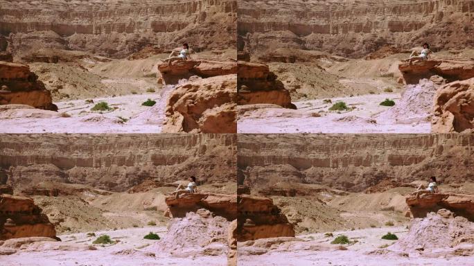 坐在沙漠岩石上的女人