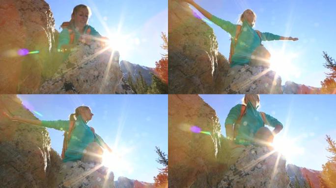 攀岩者到达山顶，双臂伸出