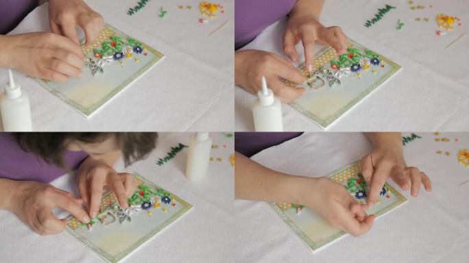 在明信片上粘贴预先剪好的彩色纸张曲线、树叶和花朵。