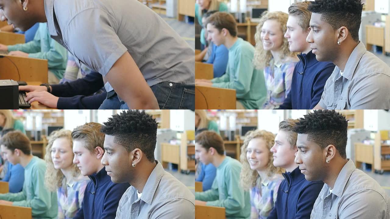 一名非裔美国青少年高中生走到一排电脑前，坐下来学习