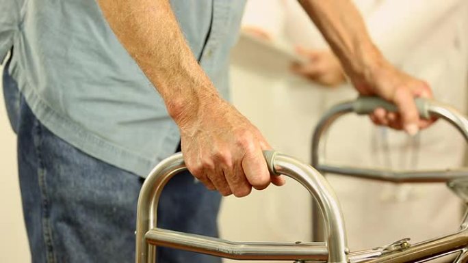 女医生帮助老年男性患者使用助行器。握着手。