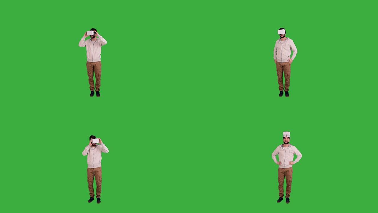 戴着虚拟现实眼镜的大胡子男人害怕绿色背景上的东西