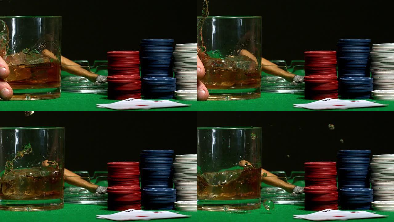 手将威士忌杯放在赌场桌子上