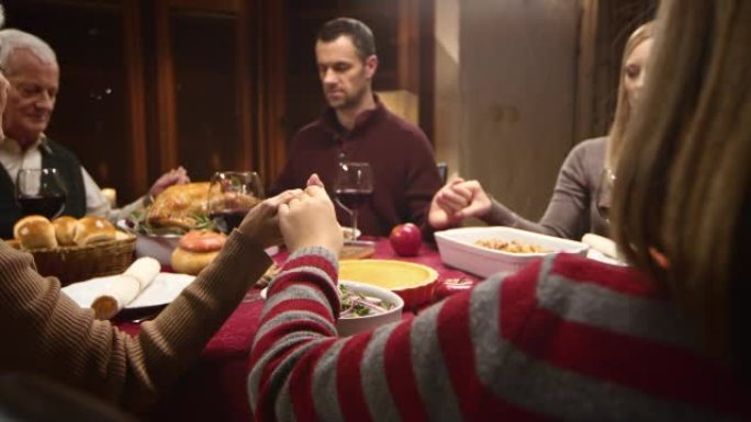 家人在感恩节餐桌上牵着手，祖母说格蕾丝