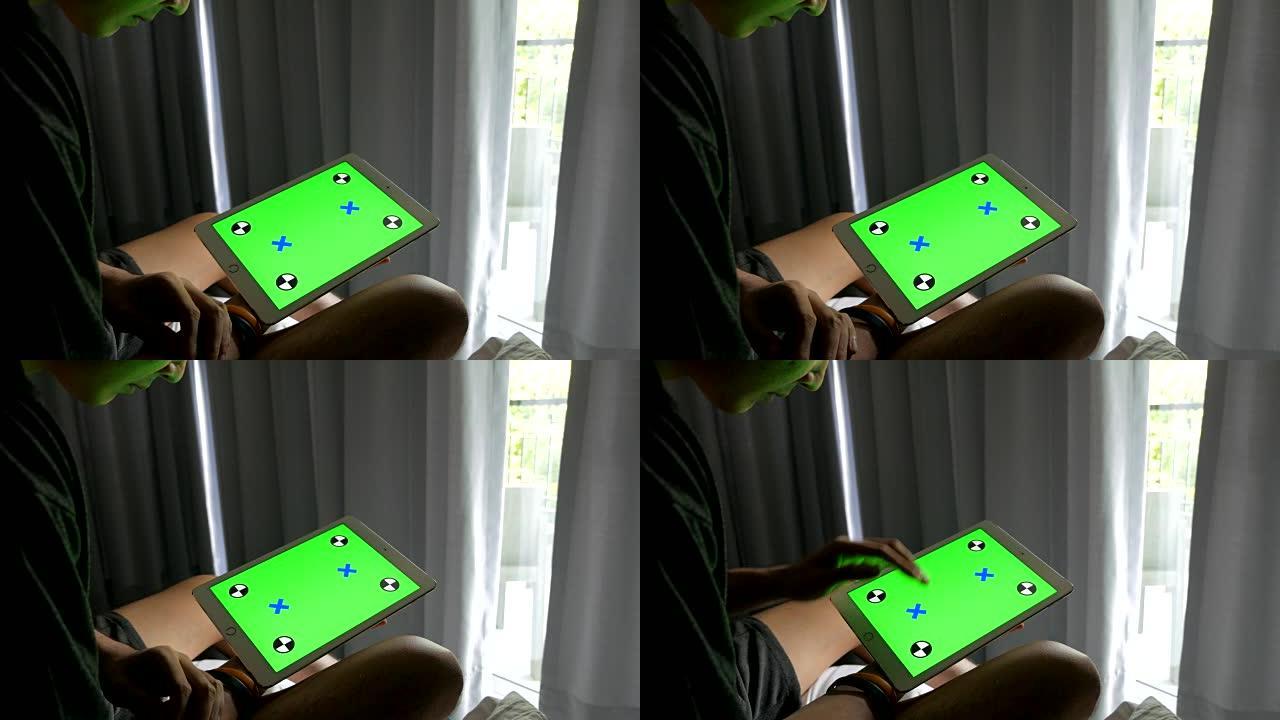 男人在家并使用带有绿色屏幕的平板电脑