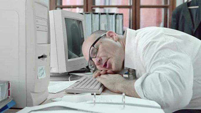 有趣的商人睡在电脑键盘上