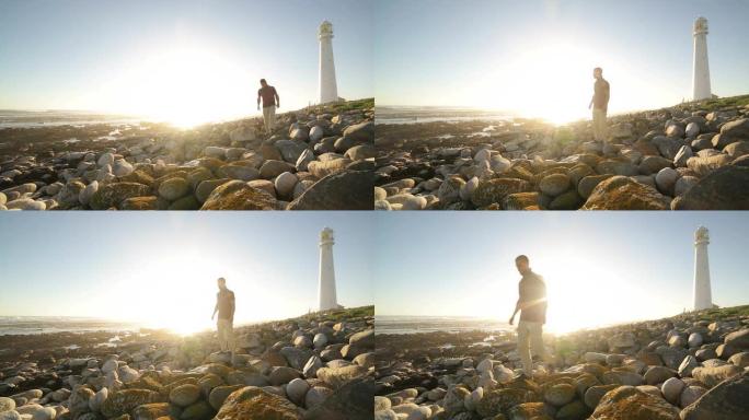日落时在岩石灯塔海滩上的人