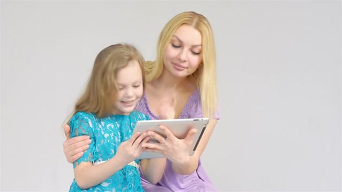 使用数字平板电脑的母亲和女儿