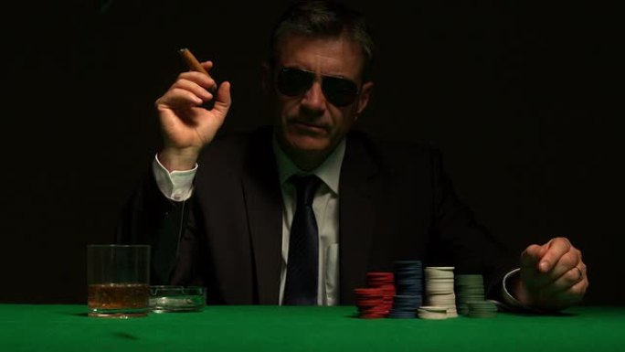 戴着太阳镜玩扑克的酷赌徒