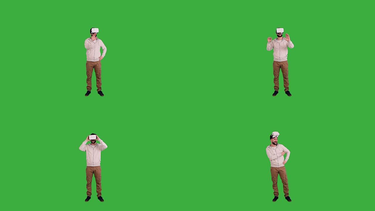 戴着虚拟现实眼镜的年轻人在绿色背景上展示了复制空间和拇指