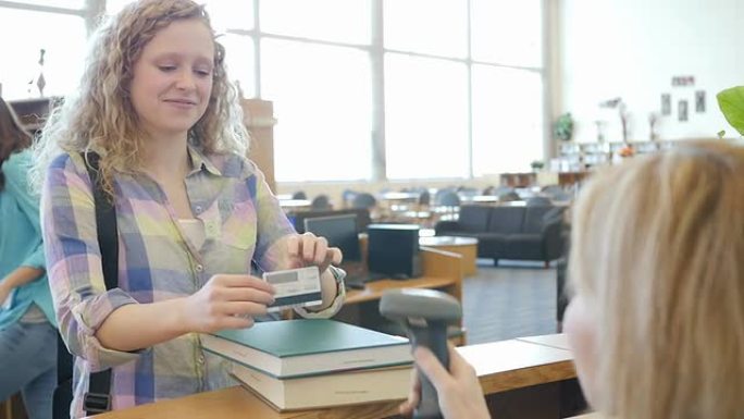 高中女生持图书馆身份证在图书馆收银台结账