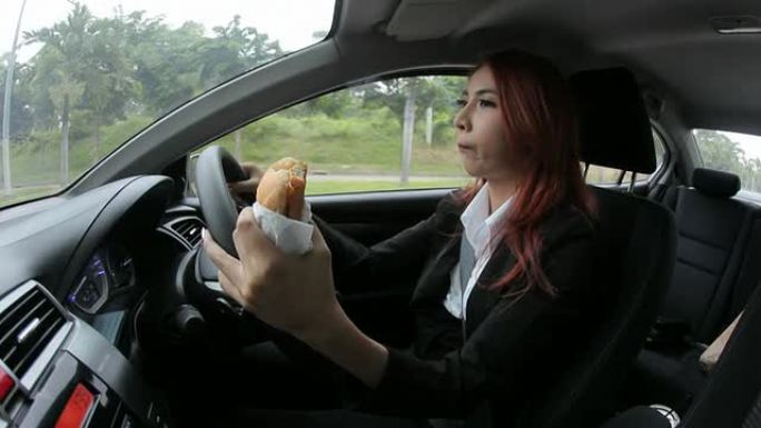 开车上班时吃东西的女人