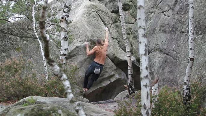 一名肌肉发达的年轻男子在枫丹白露地区攀登巨石