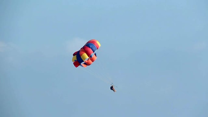 乘船拖曳的彩色降落伞上的游客。