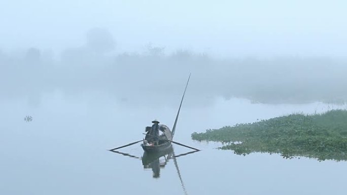 雾天宁静湖水上的小渔船