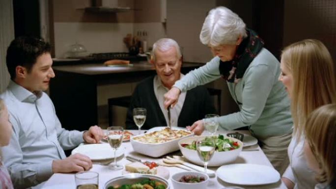 奶奶在家庭晚宴上供应千层面
