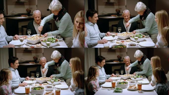 奶奶在家庭晚宴上供应千层面