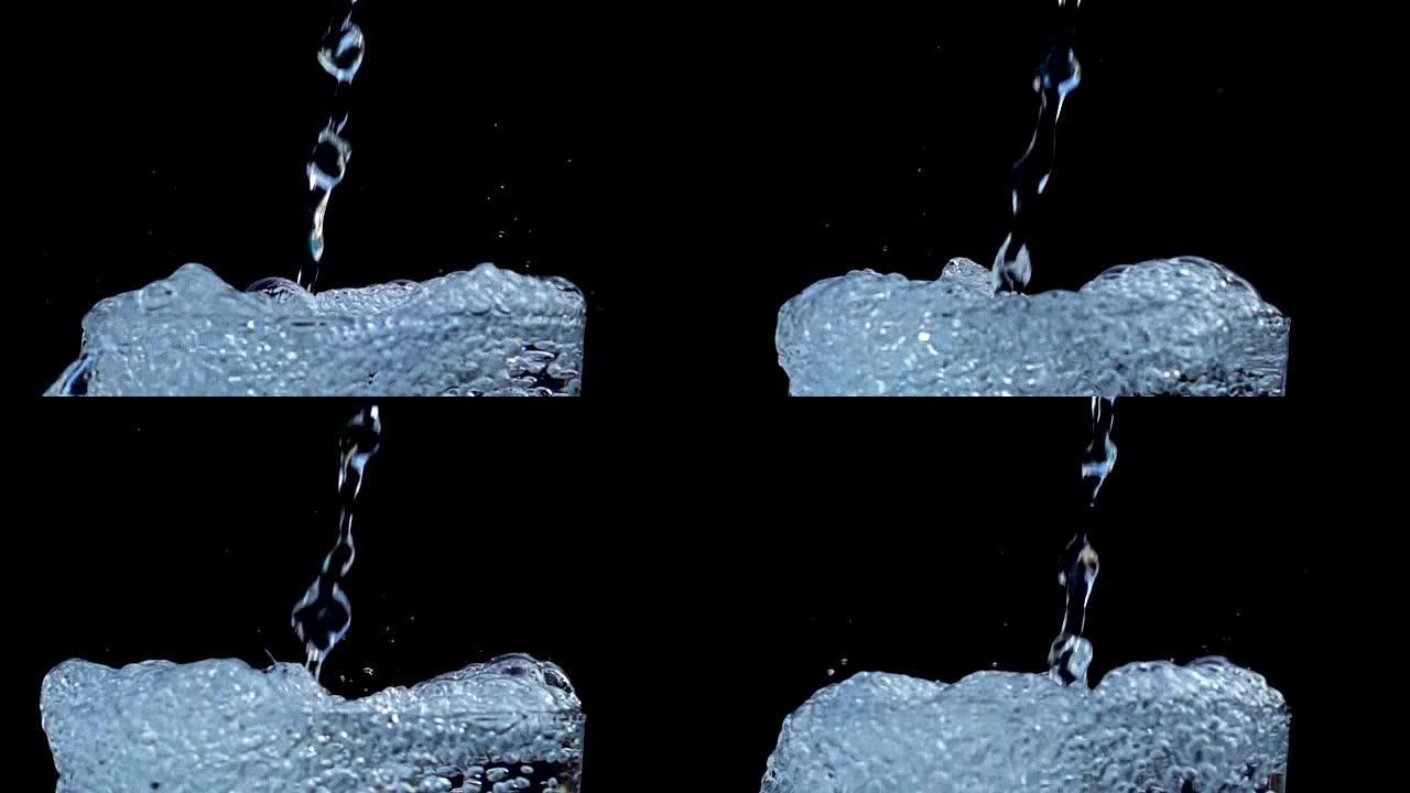 在黑色背景上慢动作时，水倒入冰杯中飞溅