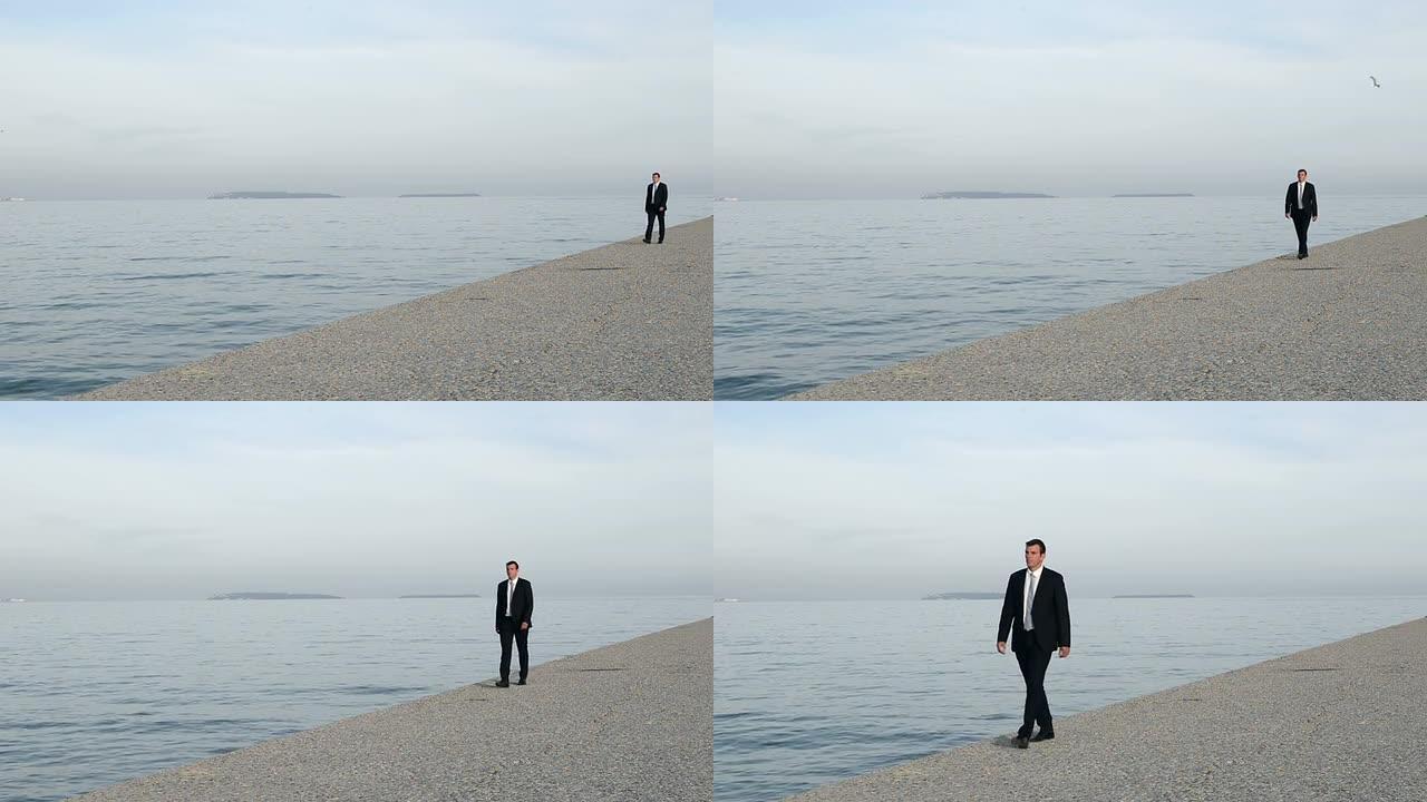 一名身穿黑色西装的男子在海滩散步
