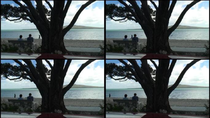（HD1080i）情侣坐在海滩上，世界擦肩而过
