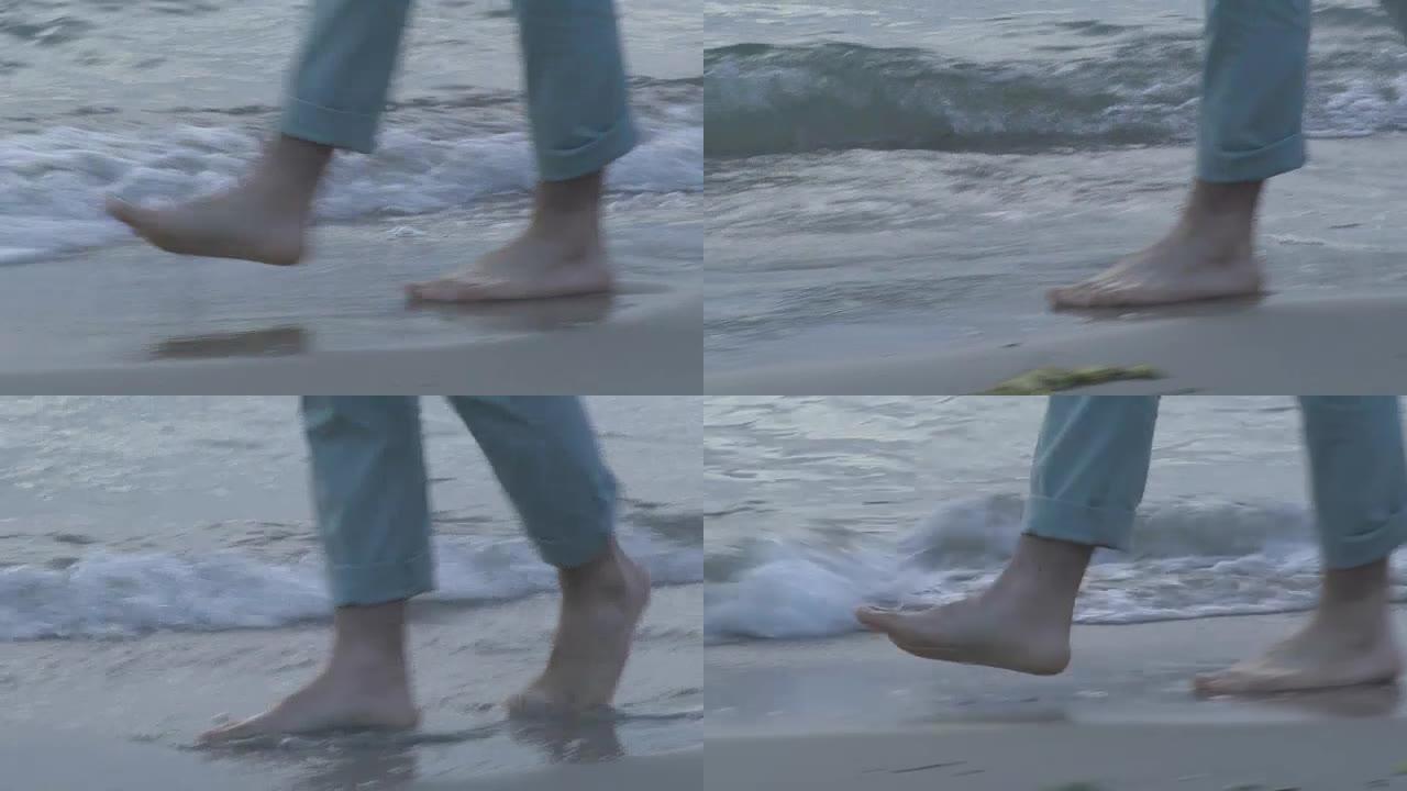 男子在海滩上散步脚步光脚海浪