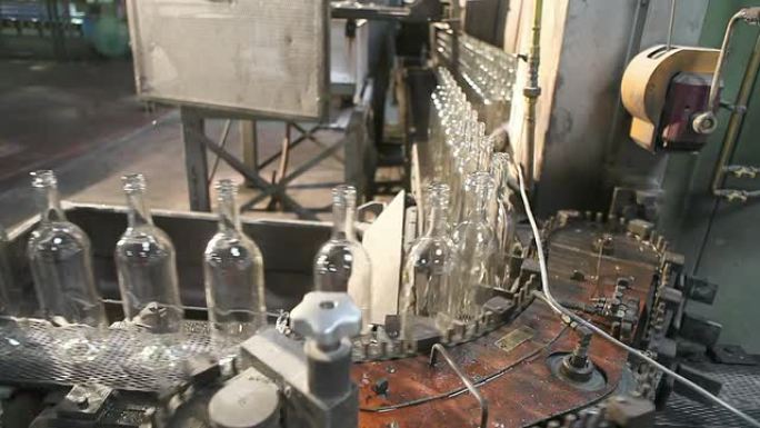 玻璃工厂。瓶子被安排在一个弯曲的输送机上。