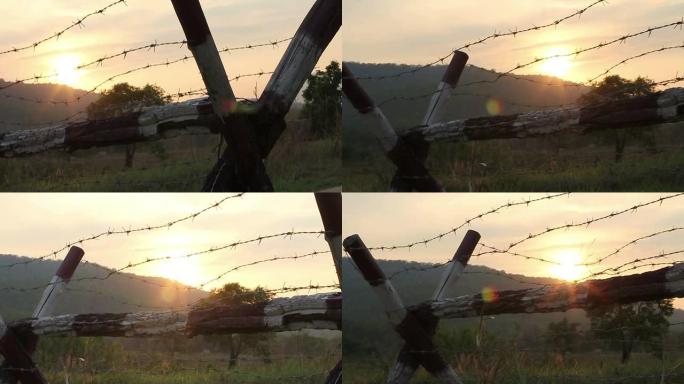 铁丝网和Mountian背后的日落