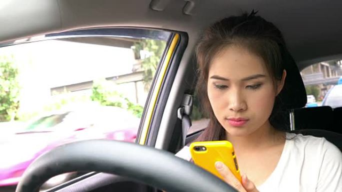 在汽车上使用智能手机的女孩
