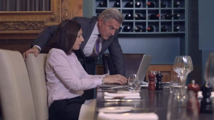 MS商务人士使用笔记本电脑并在餐厅聊天