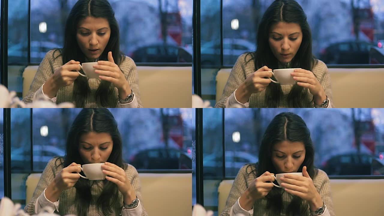 年轻女子在茶馆里喝热茶。