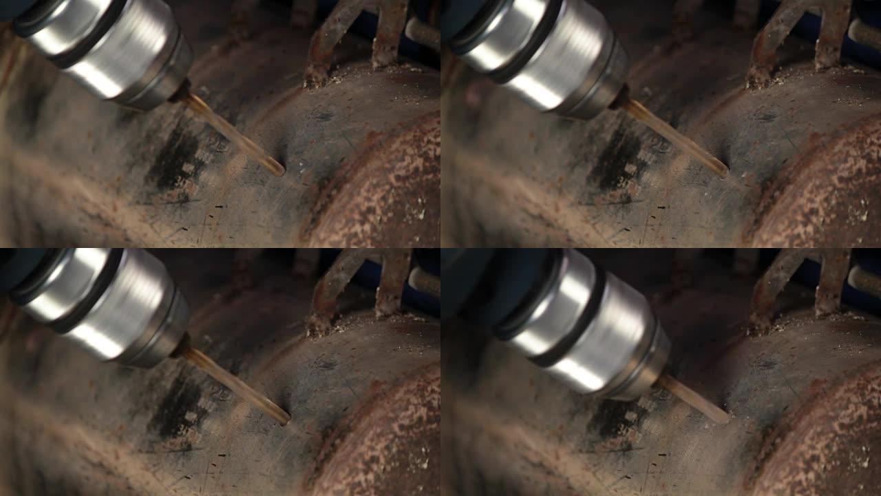 工人用钻头在铁板上打孔