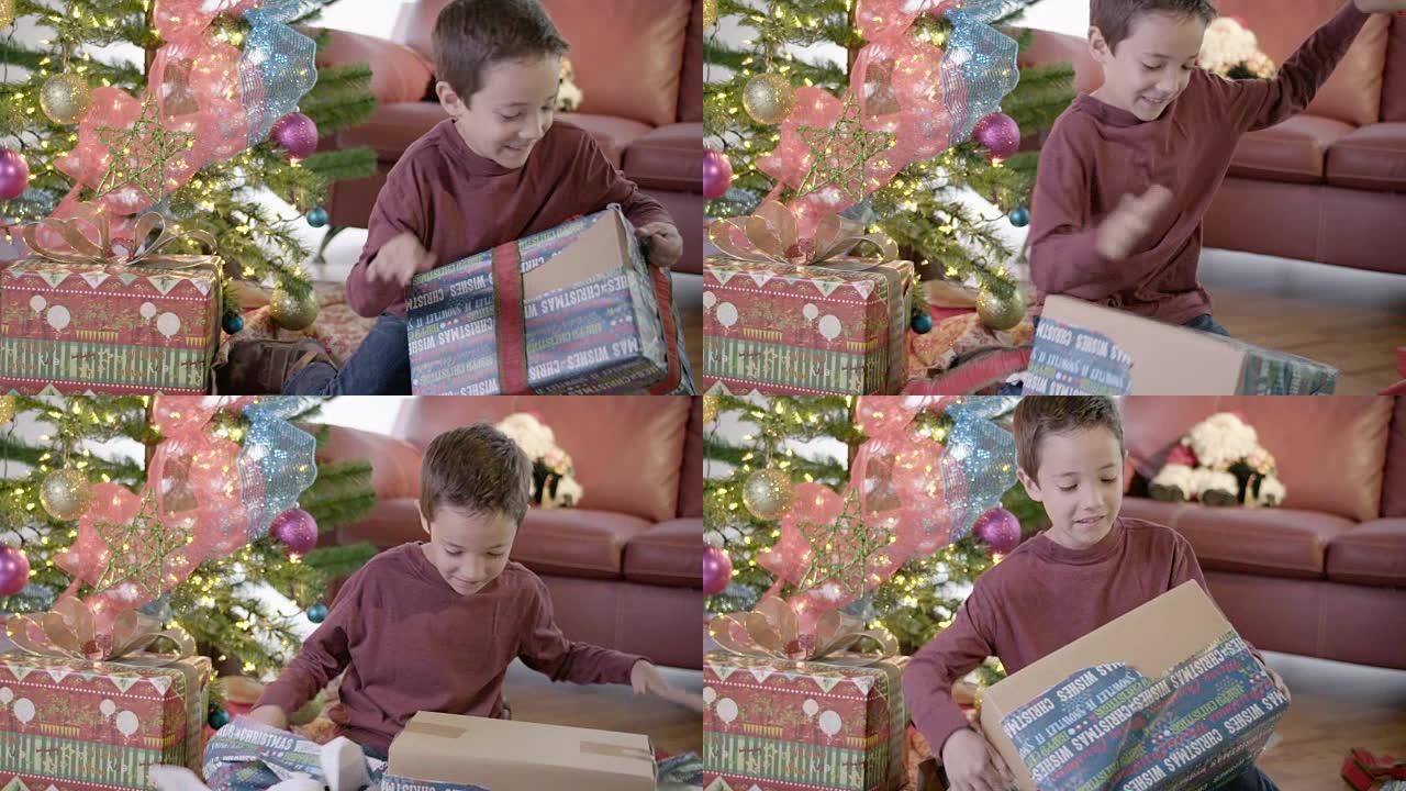 男孩在圣诞树上解开礼物