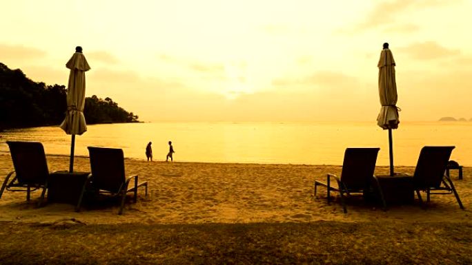 延时-海滩上带雨伞躺椅的日落