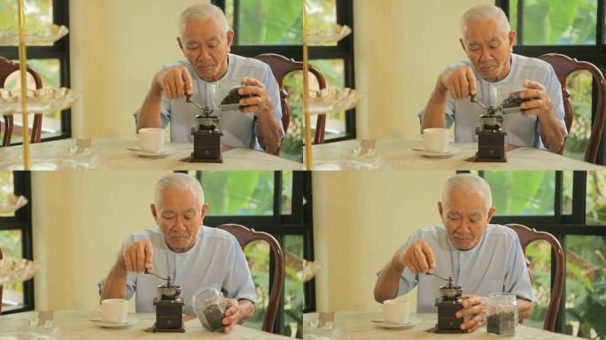 亚洲资深男子与老式咖啡研磨机