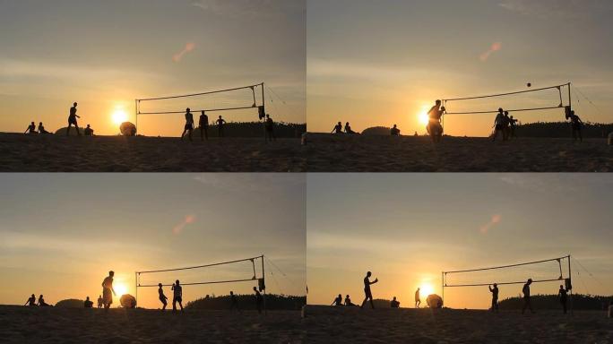日落时沙滩上排球运动员的剪影