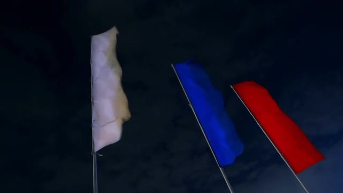 三面旗帜在夜空中飘扬