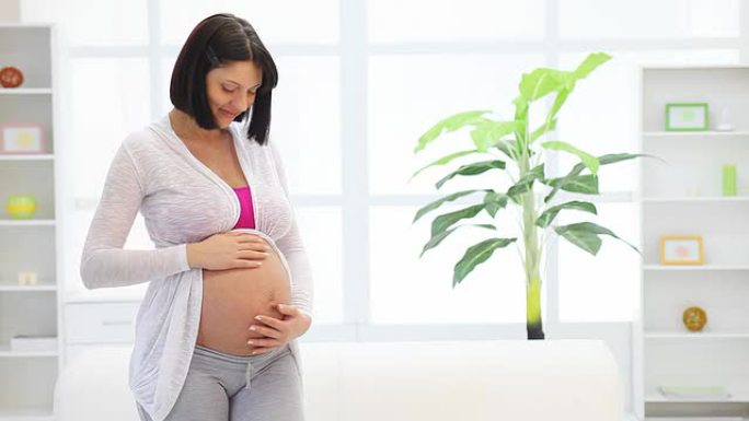 孕妇抚摸着她的大肚子。