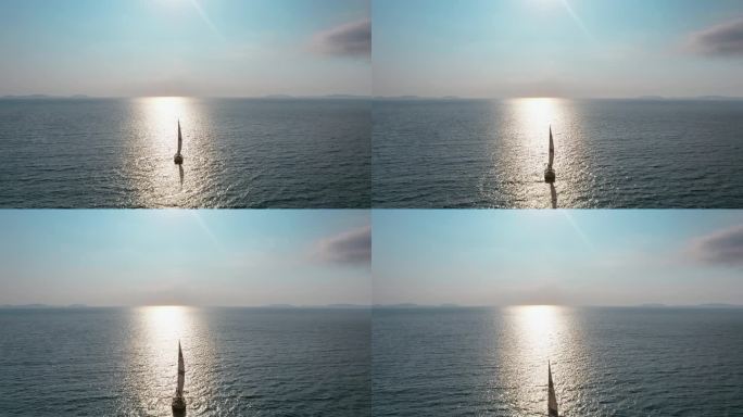 朝阳下迎着海平线航行的帆船