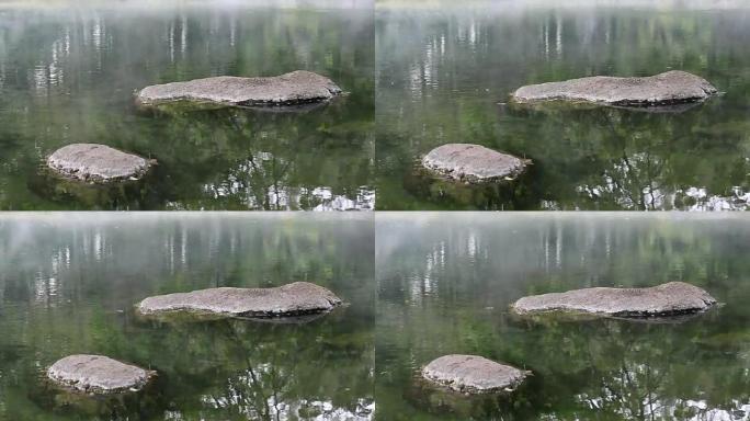 温泉湖面上的石头水面烟雾宁静的湖面