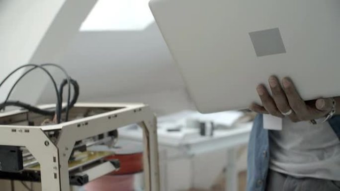 高清：非洲裔美国人在3D打印机旁工作。