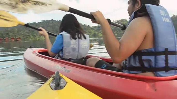一对夫妇在泰国切兰湖划独木舟