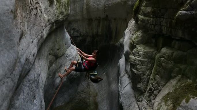 一名女子使用固定绳索在峡谷深处穿行