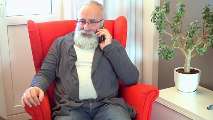 白胡子的成年老人讲智能手机